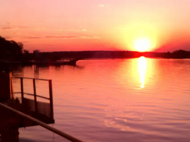 The sun setting over the Zambezi River, its reflection glowing on the water